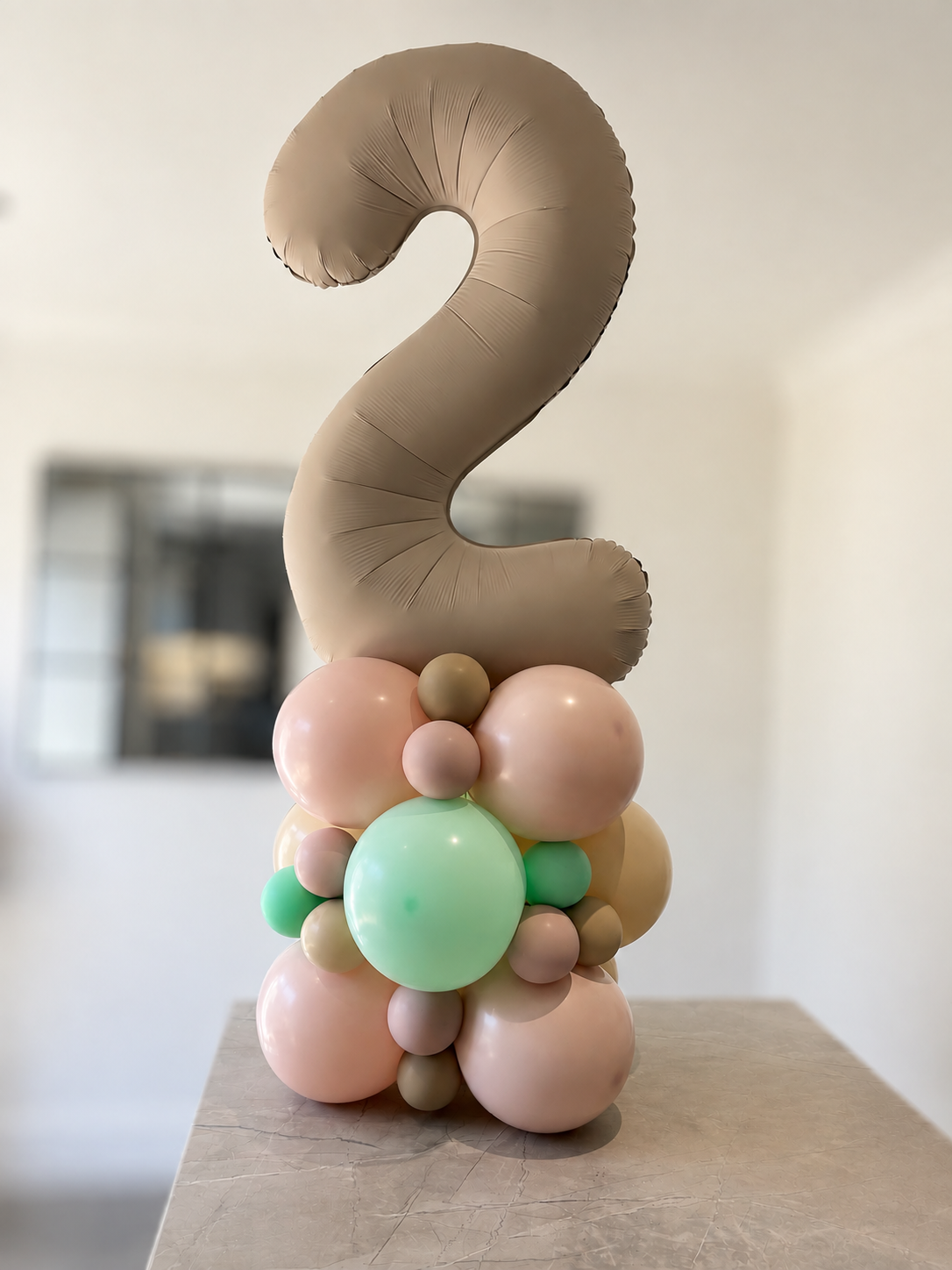 Pastel number balloon stack in pink, mint and taupe tones